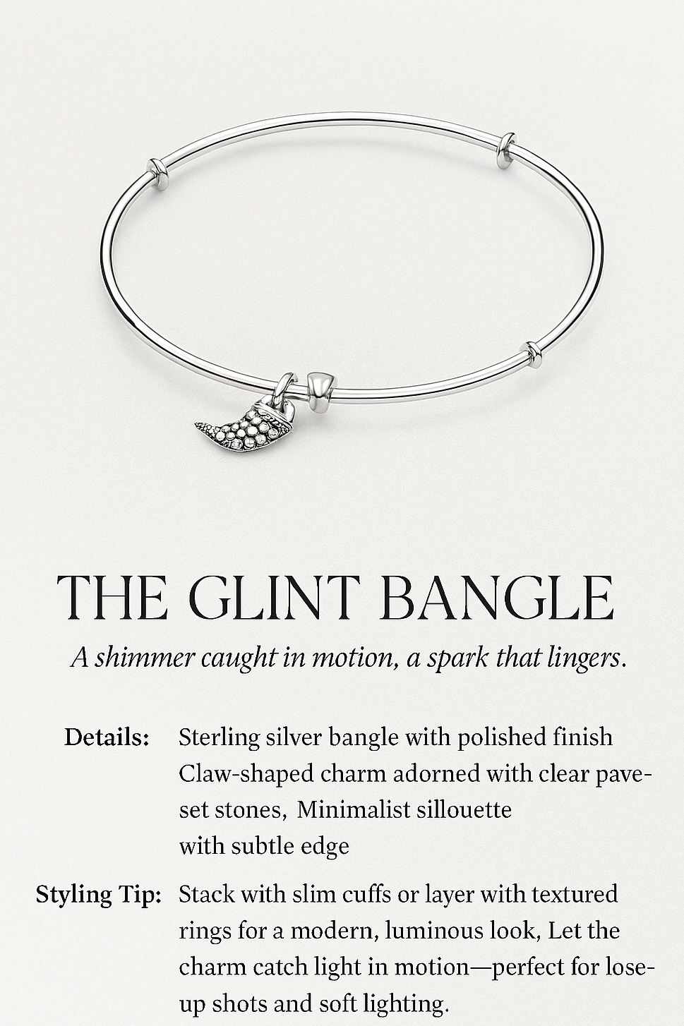 Silver bangle with a claw-shaped charm on a white background