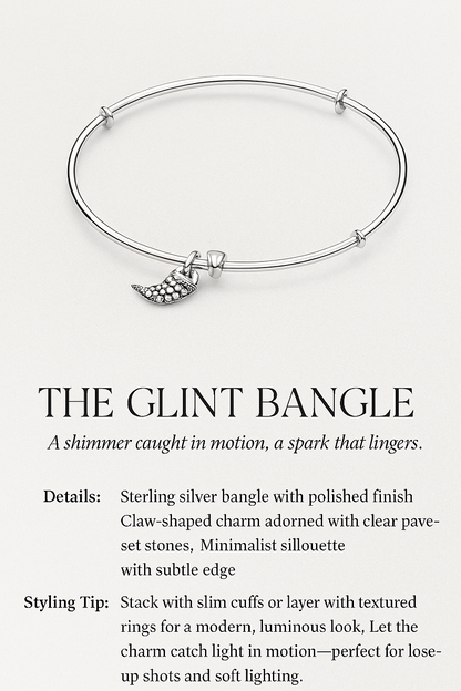 Silver bangle with a claw-shaped charm on a white background