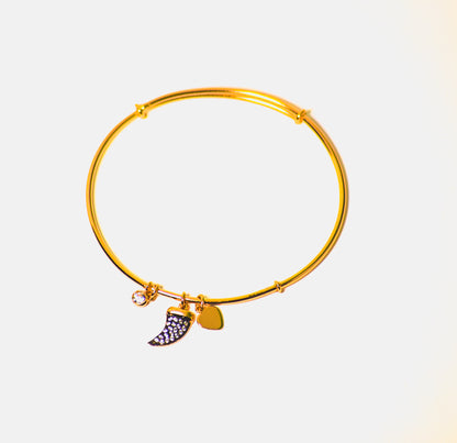 An adjustable gold-colored bracelet with a modern style horn pendant.